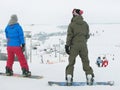 Two girls (snowboarder) are standing on the snowy background.